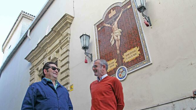 José María Roldán y Manuel Bernal ante el azulejo del Cristo de la Lanzada.