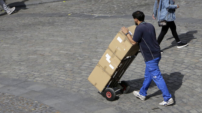 Un trabajador transporta unas cajas para su entrega en una empresa del centro.