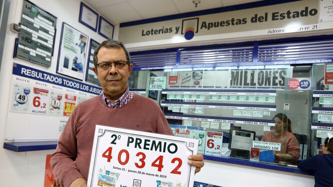 El propietario de la Administración 21, Manuel Montes, posa ayer ante la misma con el número del segundo premio.