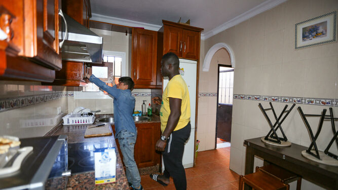 Dos jóvenes en la cocina del piso de la asoación Afasode en Chiclana.