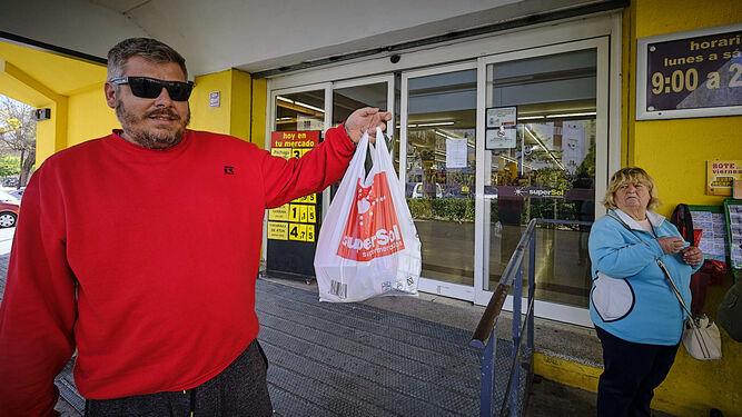Un cliente de Supersol en la avenida del Perú muestra una bolsa de compras.