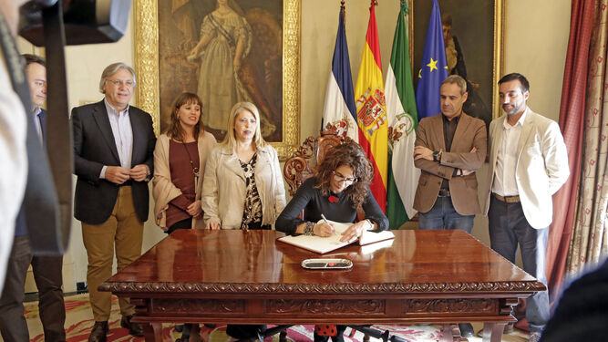 La ministra firma en el libro de honor del Ayuntamiento.