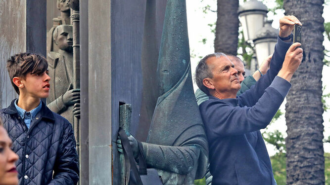 Turistas se hacen un 'selfie' junto al monumento a las cofradías de Cristina, el pasado Jueves Santo.