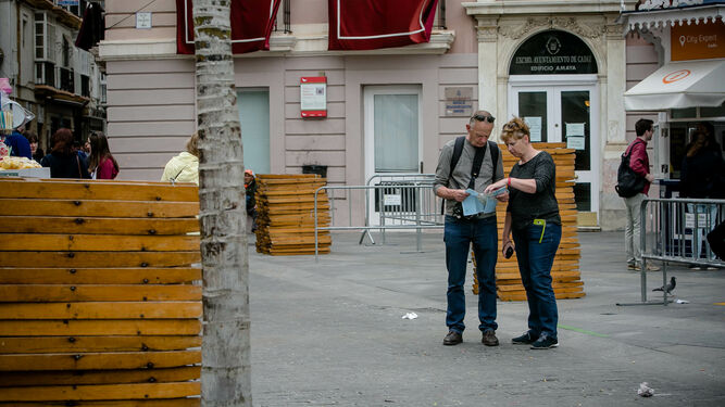 Dos turistas  consultando un mapa en la plaza de San Juan de Dios, en Cádiz, durante la pasada Semana Santa.