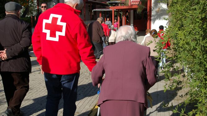 Un voluntario de Cruz Roja acompaña a mujer a votar en las pasadas elecciones
