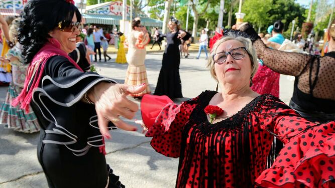 Dos mujeres ataviadas de flamenca, bailando en el Real de la Feria de Primavera.