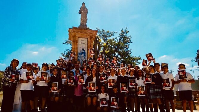 En la imagen, misioneros, profesores y alumnos posan ayer ante la estatua del Sagrado Corazón en el colegio.
