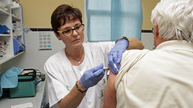 Personal sanitario administrando la vacuna de la gripe.