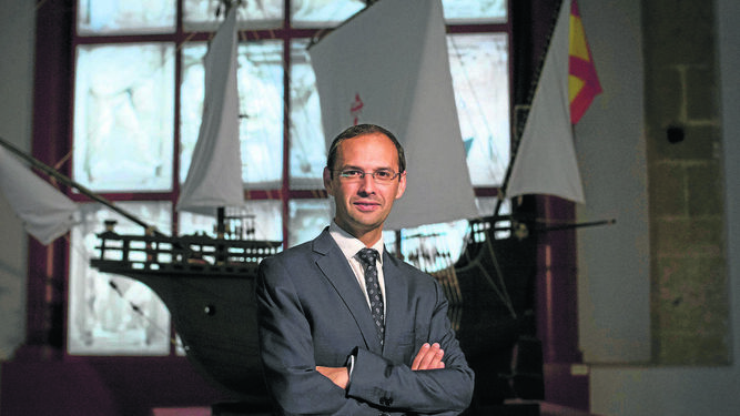 El alcalde de Sanlúcar, Víctor Mora, posa con una reproducción de la nave que dio la primera vuelta al Mundo.