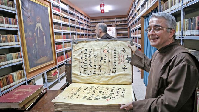El padre Alejandro Peñalta mostrando libros litúrgicos de la importante biblioteca.
