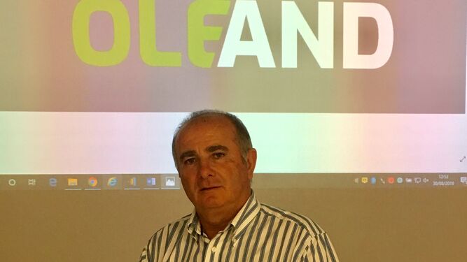 Antonio Candil ante el logo de la nueva cooperativas Oleand.
