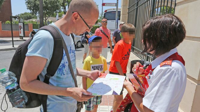 Un turista consulta este verano uno de los folletos del autobús turístico, junto a la Escuela Ecuestre.