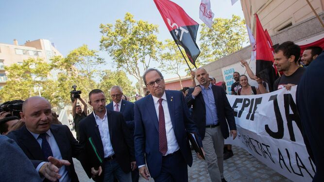 El presidente de la Generalitat, Quim Torra, pasa junto al colectivo de doctorandos en lucha ayer en Barcelona.