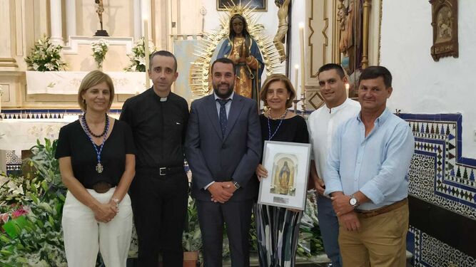 Un momento del reconocimiento a Elena Aguilar en Algar, que recibió un cuadro con la imagen de la Virgen de Guadalupe, patrona de la localidad.