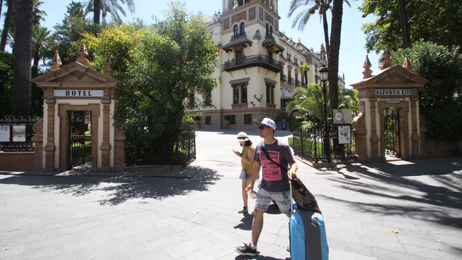 Turistas, el pasado mes de agosto, pasan ante un establecimiento hotelero en Sevilla.
