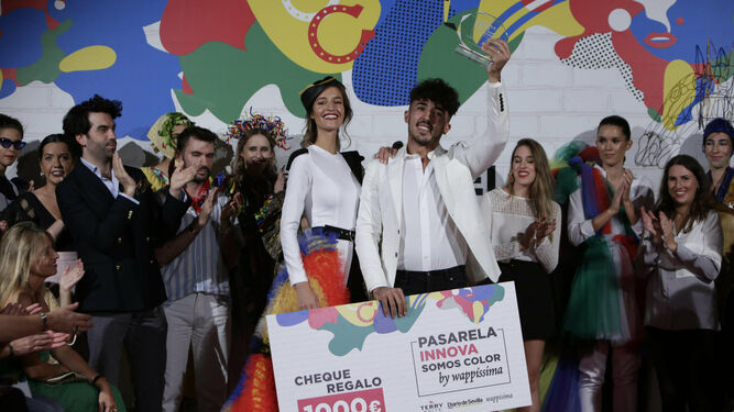 Tom Márquez, el ganador del concurso somos color, posa con la modelo que lleva su diseño, el cheque y el galardón