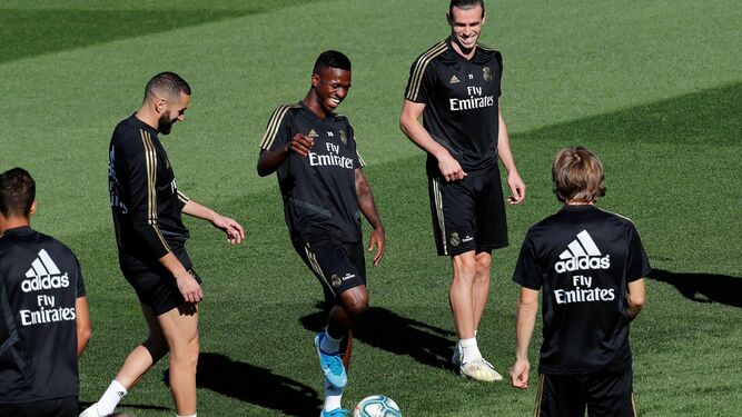 Vinicius y Gareth Bale, con Modric, de espaldas, ayer en Valdebebas.