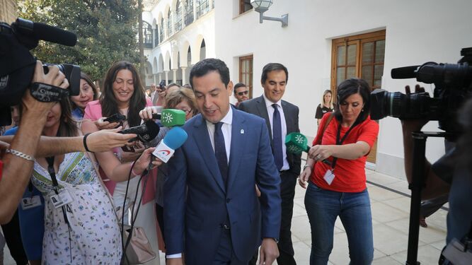 Juanma Moreno atiende a la prensa antes de entrar en el Pleno del Parlamento.