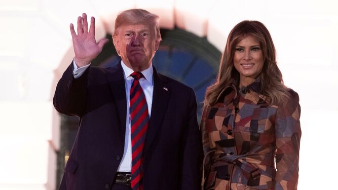 Melania Trump, con gabardina de Michael Kors, junto a su marido en la recepción de Halloween en la Casa Blanca.
