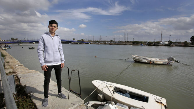 Hamza posa delante de unos barcos amarrados a la ribera del Guadalete.