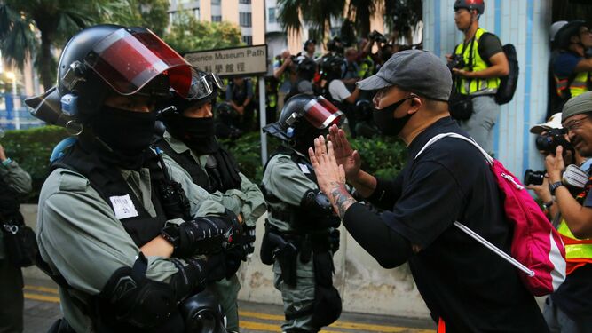 Un manifestante se dirige a un agente antidisturbios en la Universidad Politécnica de Hong Kong.