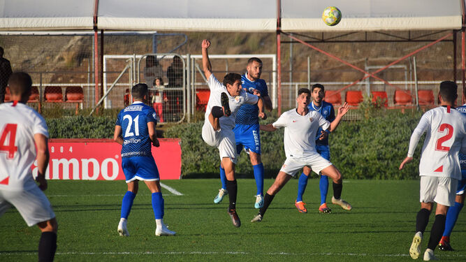 Álex Colorado, pugnado con un jugador del Sevilla C por un balón bombeado en el partido del pasado domingo.