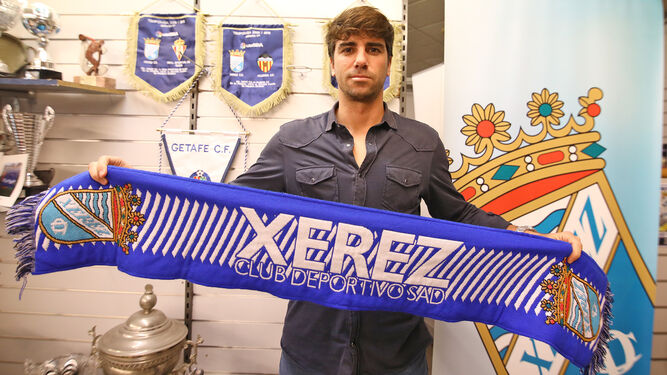 Manu Lebrón posa con la bufanda del Xerez CD en su presentación en la sede de Afición Xerecista.