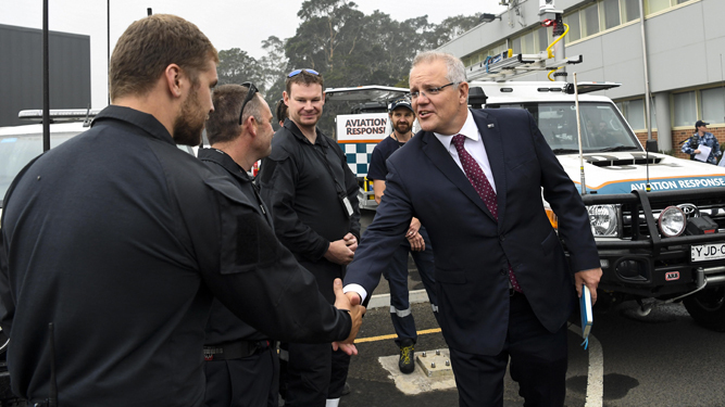 Scott Morrison, a la derecha de la imagen, saluda a varios integrantes del Grupo de Respuesta de la Aviación australiana.
