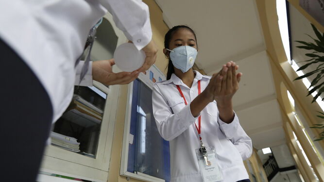 Estudiantes asiáticos se protegen contra el coronavirus con mascarillas y desinfectante de manos.