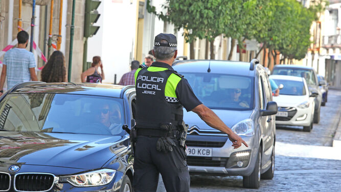 Un policía local ordena a un conductor que aparte su vehículo para pasar un control.