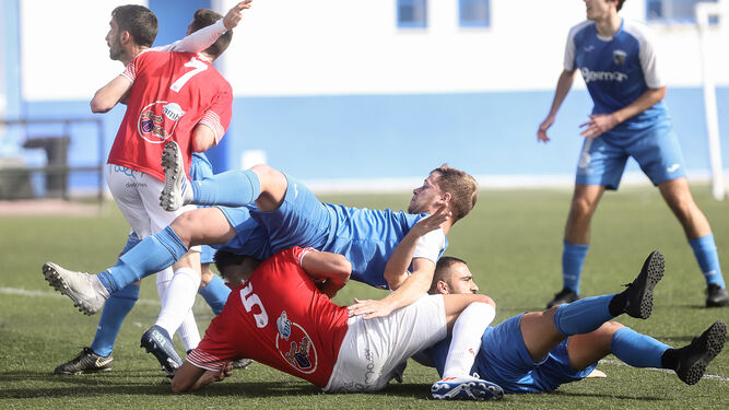 José Roldán cae encima de Alberto, que había arrollado a Sergio Iglesias.