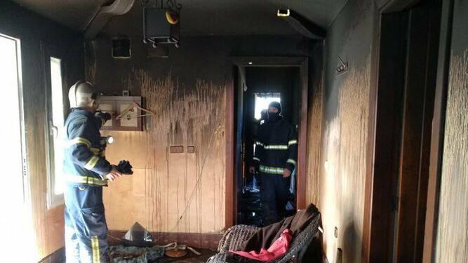 Bomberos en el interior de la casa tras la exitinción del incendio.