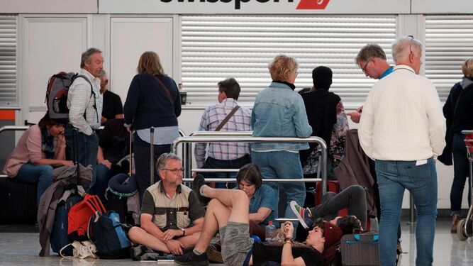 Varios viajeros, descansan en el aeropuerto de Gran Canaria, que quedó inoperativo por el fuerte viento y la densa calima