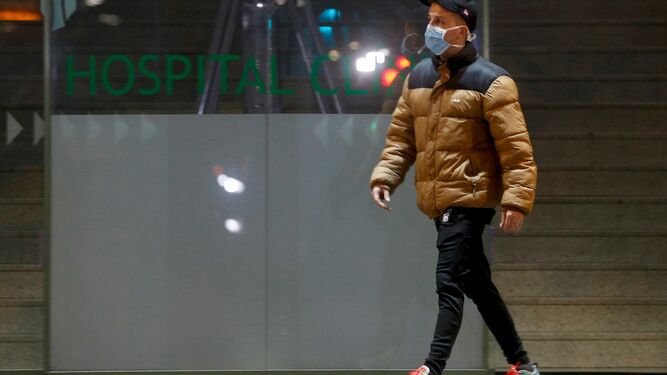 Un ciudadano con una mascarilla pasando por el Hospital Clinic de Barcelona.