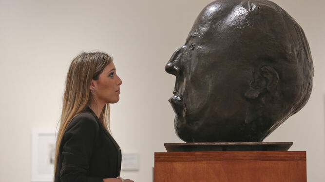 Asistente mira atentamente la escultura de Antonio Machado por Joaquín Peinado