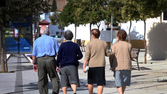 Cuatro personas mayores pasean por la ciudad.