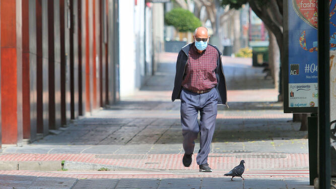 Un hombre camina ataviado con una mascarilla.