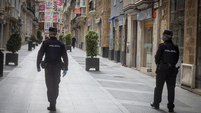 Policías nacionales pasando por la calle Ancha de Cádiz.