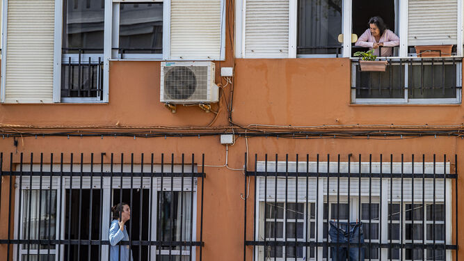 Dos vecinas, en una barriada de San Fernando, conversan de balcón a balcón durante el confinamiento.