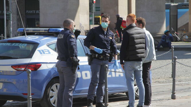 Policías italianos controlan a transeúntes en Milán.