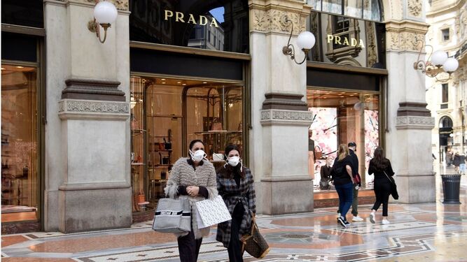 Dos mujeres con mascarilla frente a una tienda de Prada en Madrid.