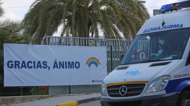 Una ambulancia pasa ante un cartel en el que se da ánimos a los profesionales sanitarios, en el recinto del hospital de Jerez.