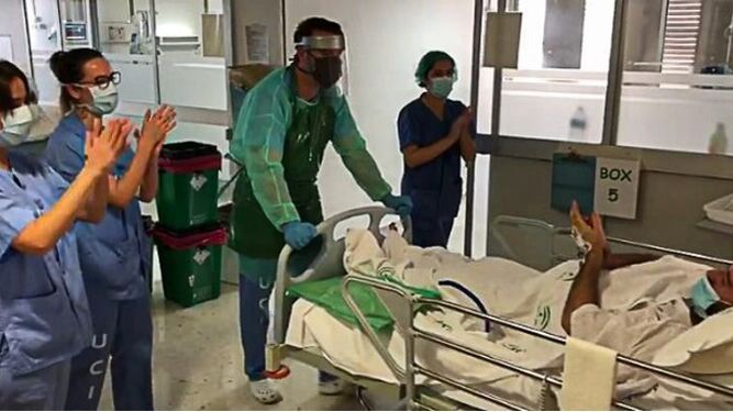 Los profesionales sanitarios arropan la salida a planta del primer paciente que recibió el alta en la UCI del Hospital de Valme.