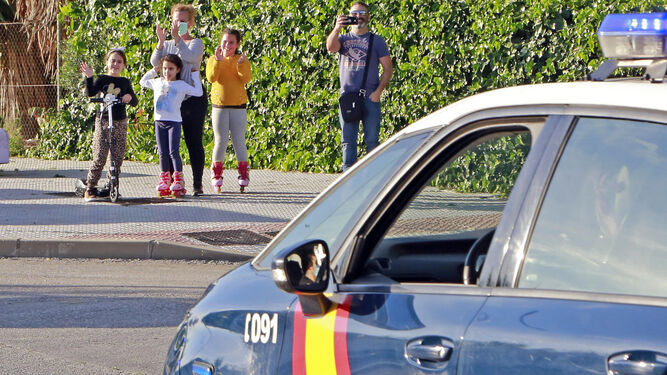 Niños paseando el pasado domingo ante un patrulla de la Policía Nacional.