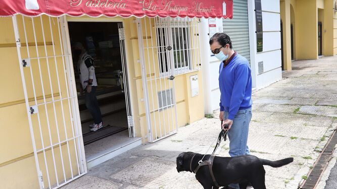 Arturo Díaz y con su perra guía Idena en un comercio de su barrio, días atrás.