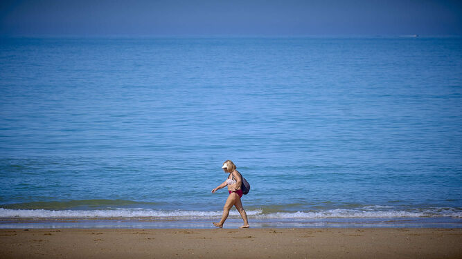 Playas de Conil. Una mujer camina por la orilla de La Fontanilla.