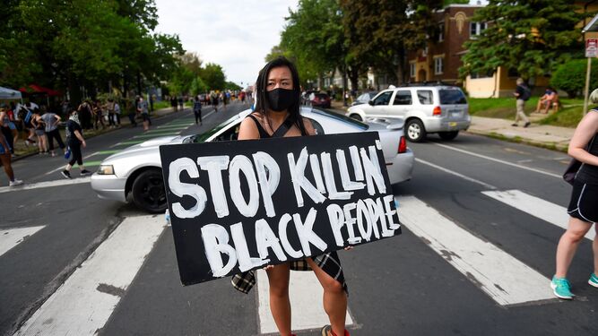 Una activista porta un cartel en el que se pide que no asesinen a los negros