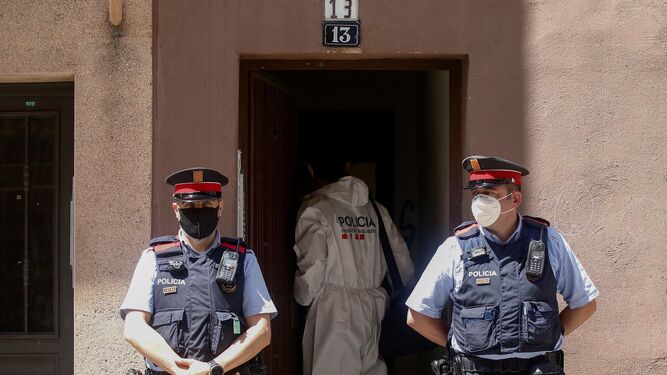 Los mossos vigilan la entrada donde se ha encontrado el cuerpo sin vida de la mujer