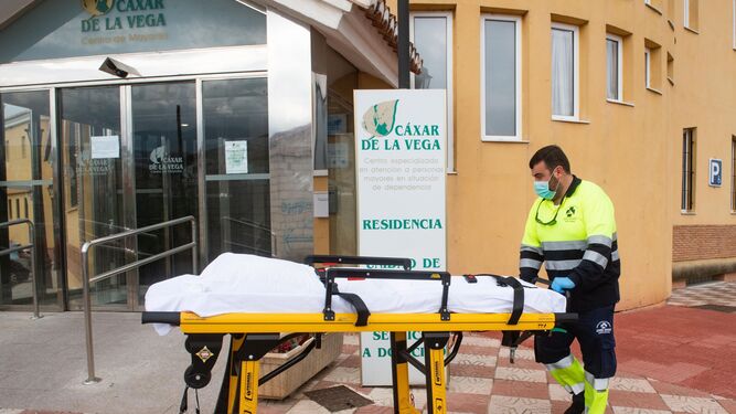 Personal sanitario traslada una camilla en la residencia  de mayores  de Cájar (Granada) donde se produjo un brote.
