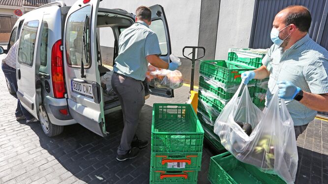Empleados del Mercadona de la calle Beethoven ayudan a cargar los alimentos en la furgoneta del Hogar San Juan.